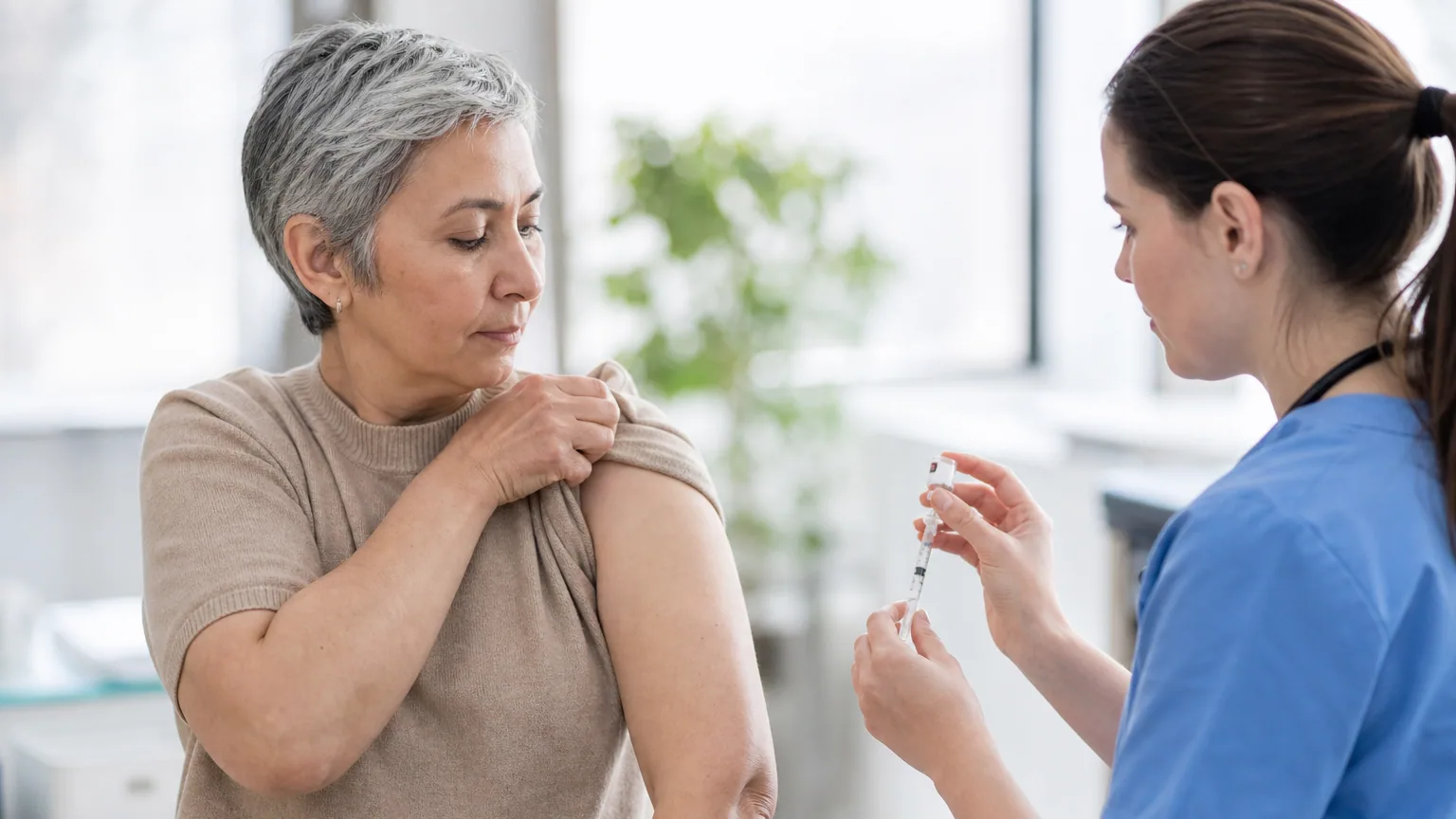 Une infirmière prépare un vaccin pour un patient adulte dans un cabinet médical lumineux