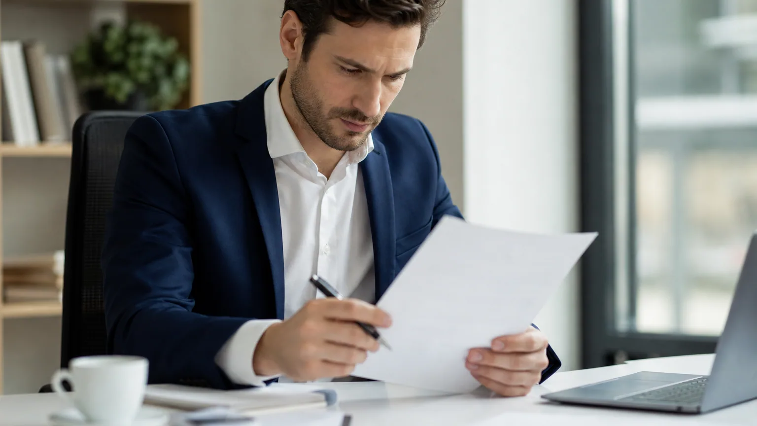 Un salarié relit attentivement son contrat de travail à son bureau avant de le signer