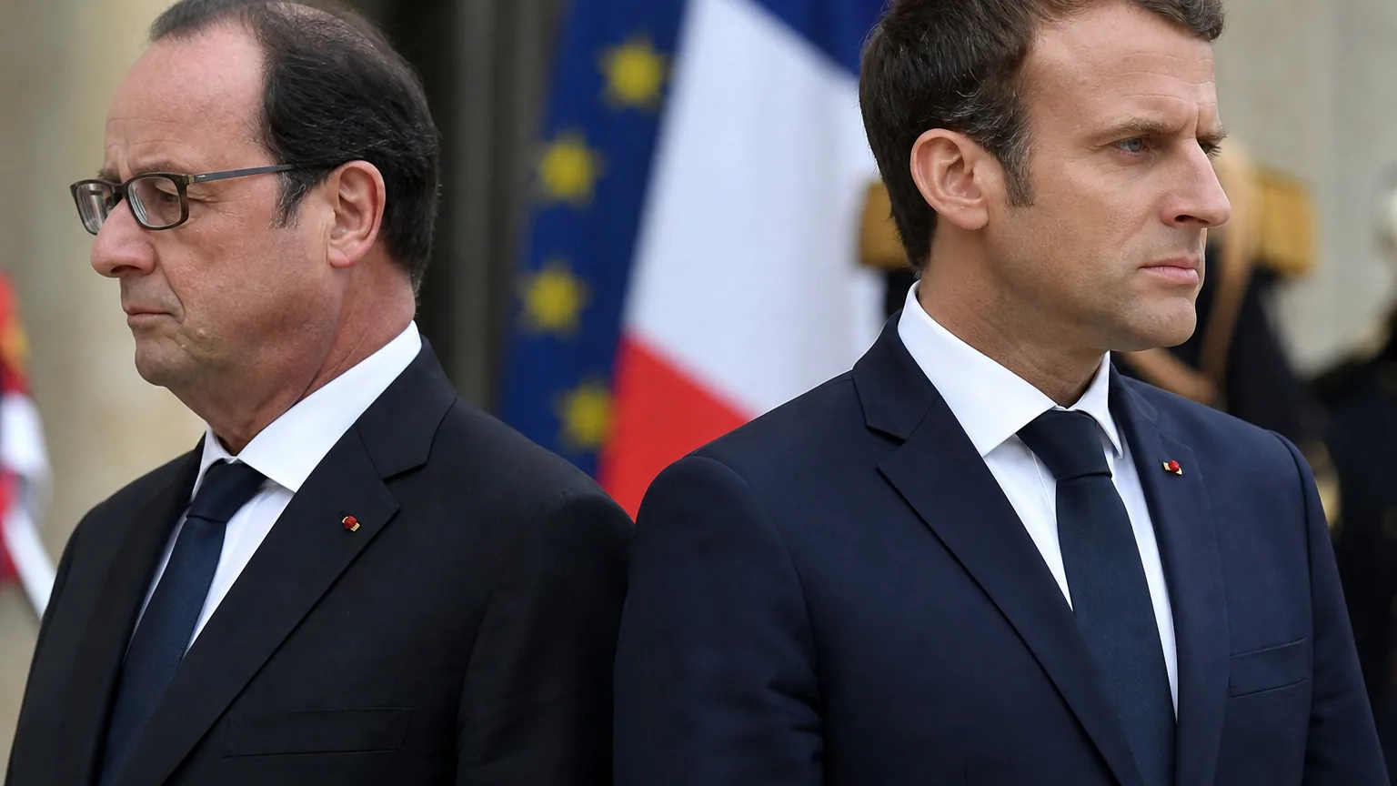 Deux responsables politiques en costume sombre côte à côte lors d'une cérémonie officielle, expression tendue.