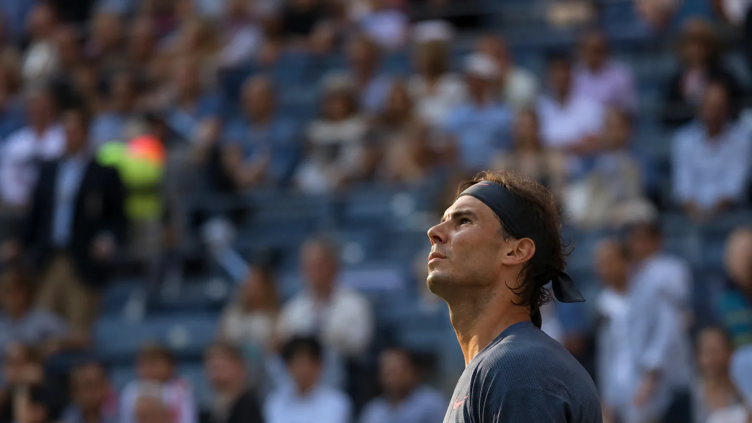 Un joueur de tennis observant un tableau d'affichage dans un stade