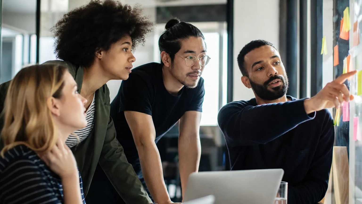 Une équipe de startup en discussion autour d'une table dans un espace de coworking lumineux