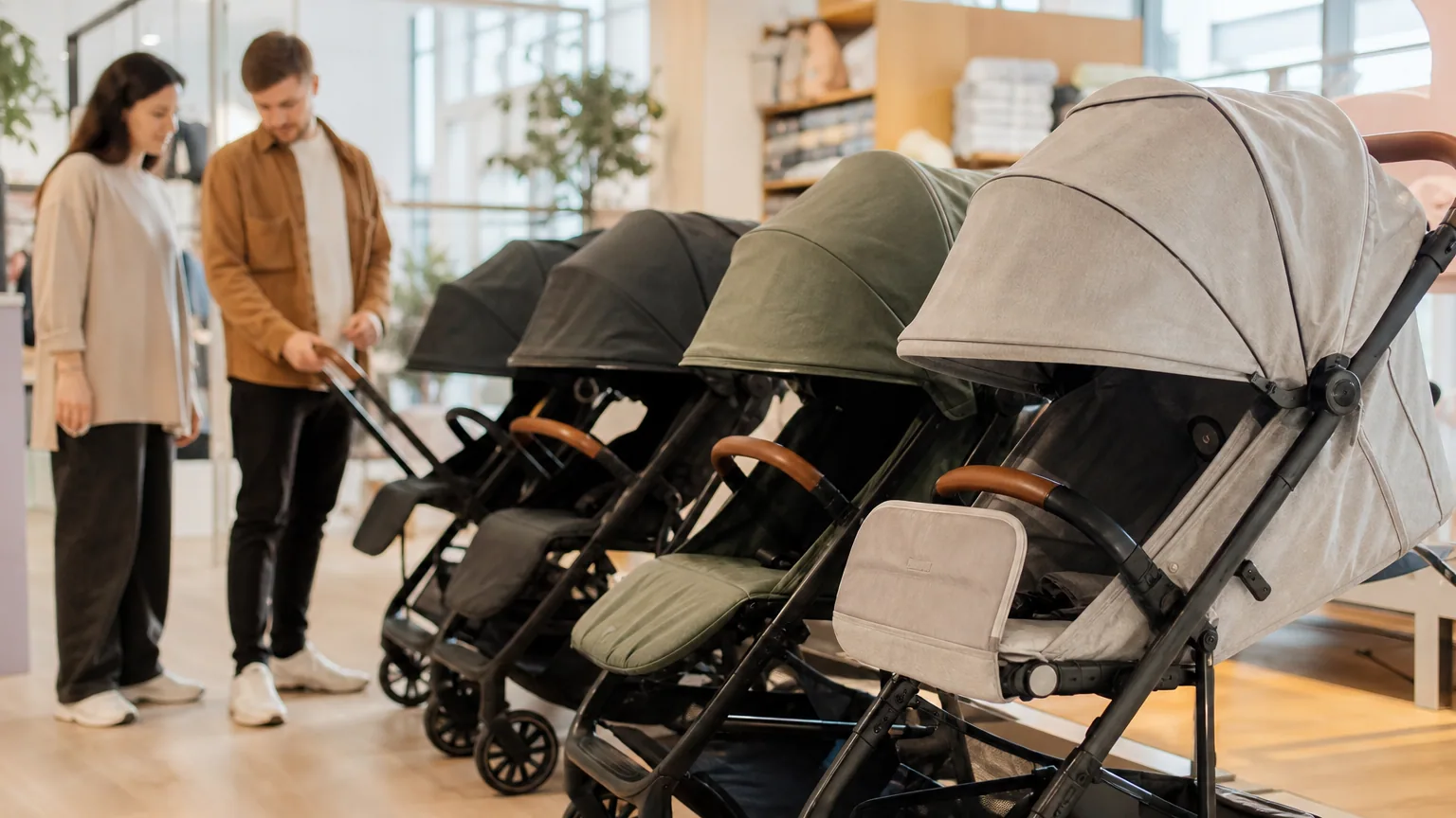 Plusieurs poussettes modernes alignées dans une boutique de puériculture lumineuse