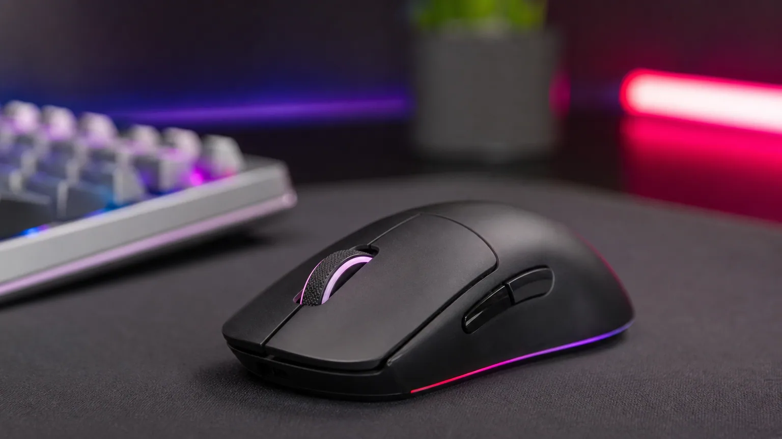 Souris gamer posée sur un tapis de bureau avec éclairage RGB en arrière-plan